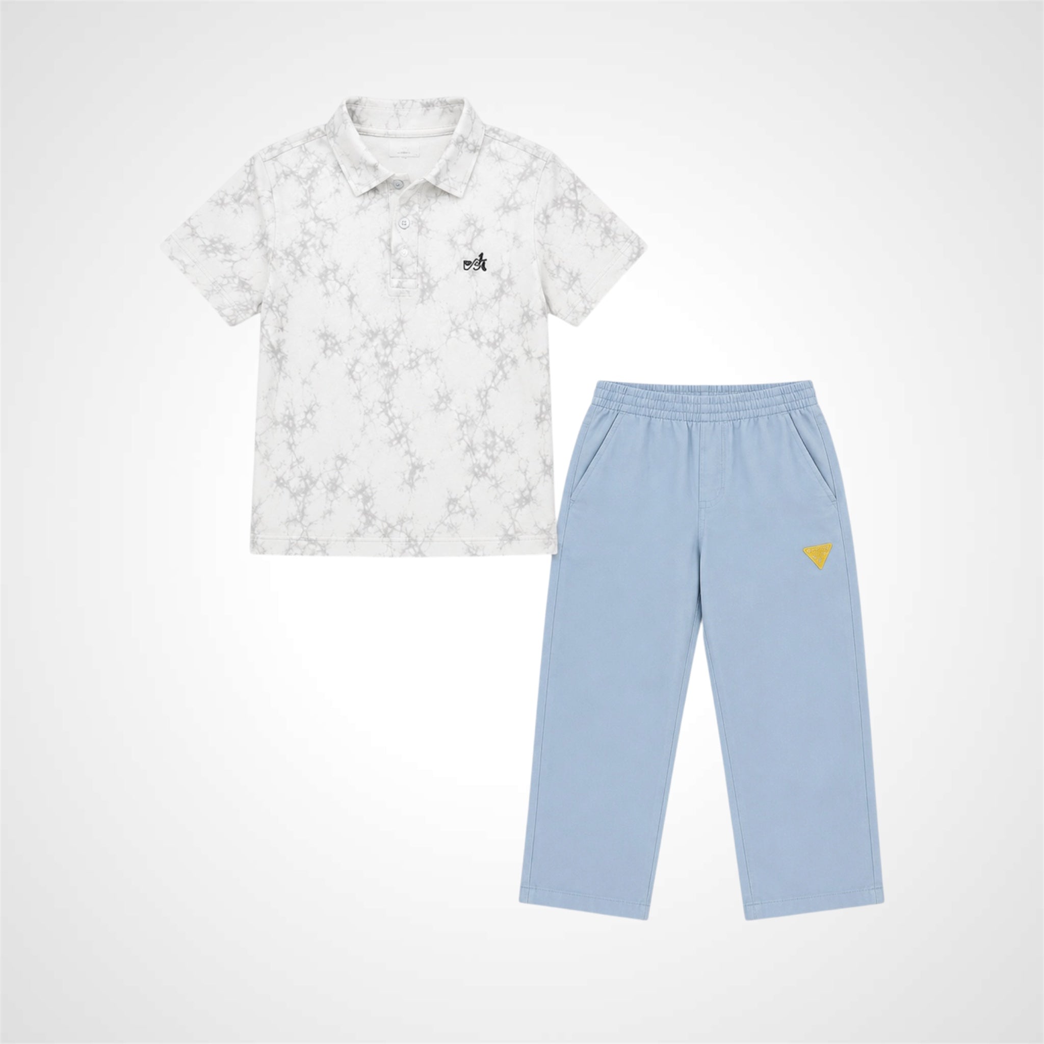A two-piece children's outfit set featuring a short-sleeve polo shirt in white with a light gray floral pattern and a small black embroidered logo, paired with light blue sweatpants that have a small yellow embroidered heart on the left thigh.