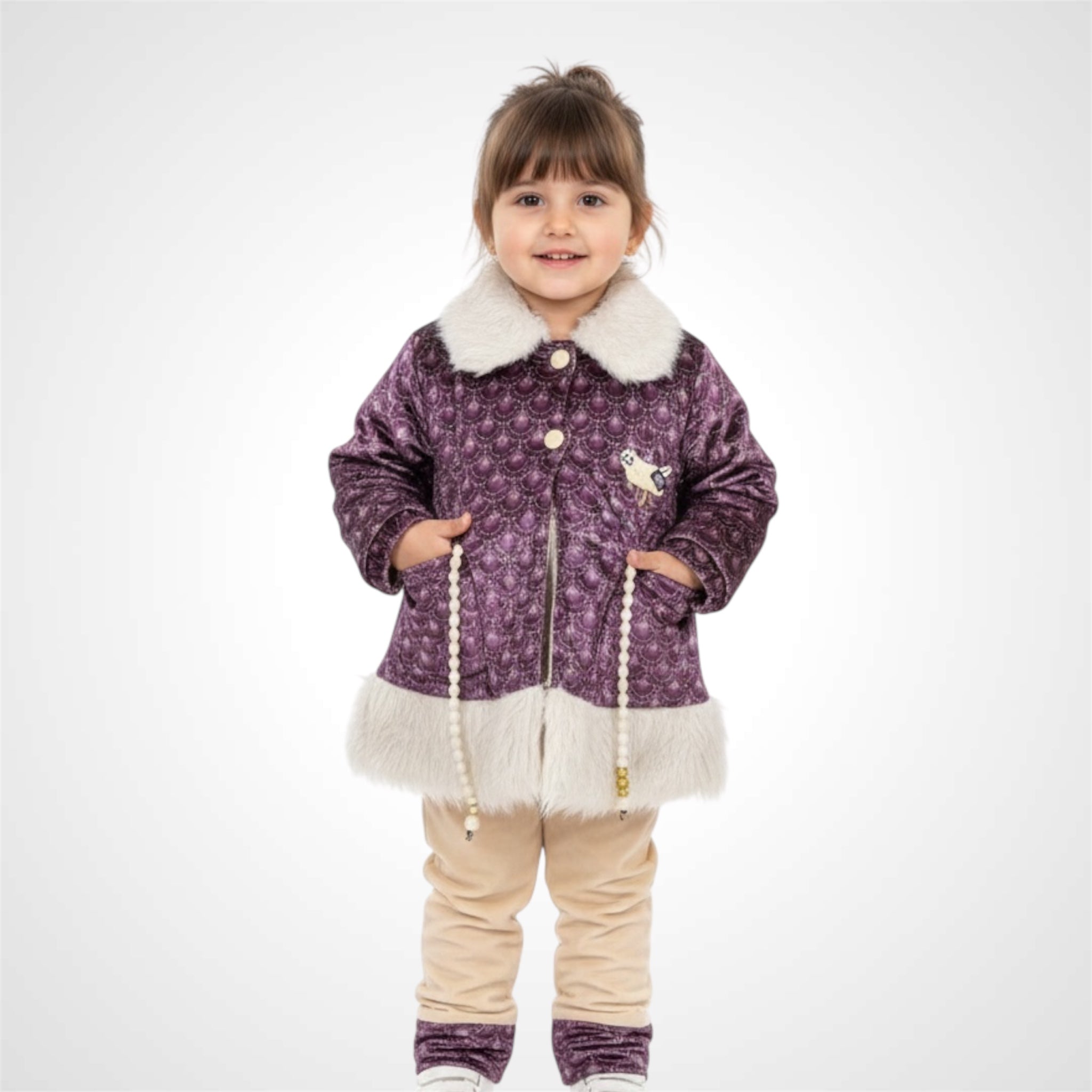 Little girl wearing a warm velvet frock style jacket and trousers for winter.