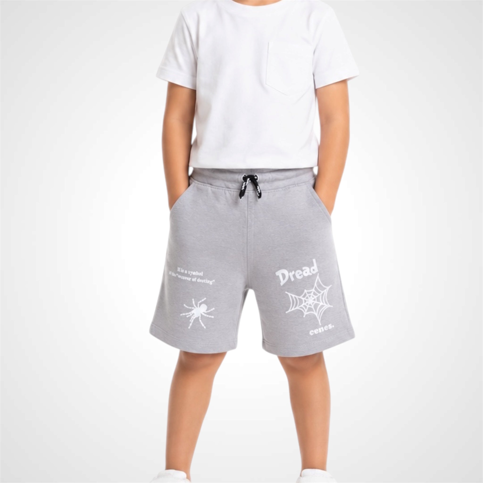 Person wearing gray shorts with white text and designs on a white background