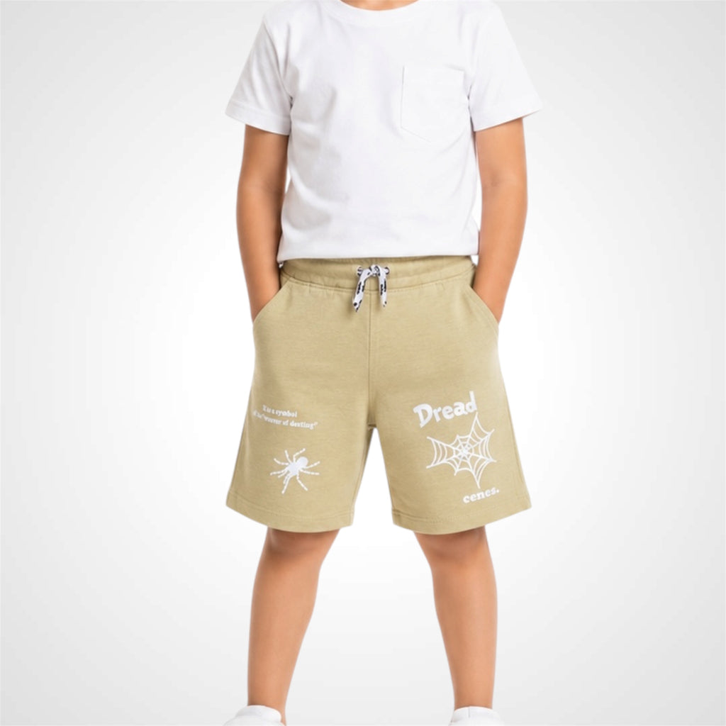 Beige shorts with white graphics worn by a person on a white background