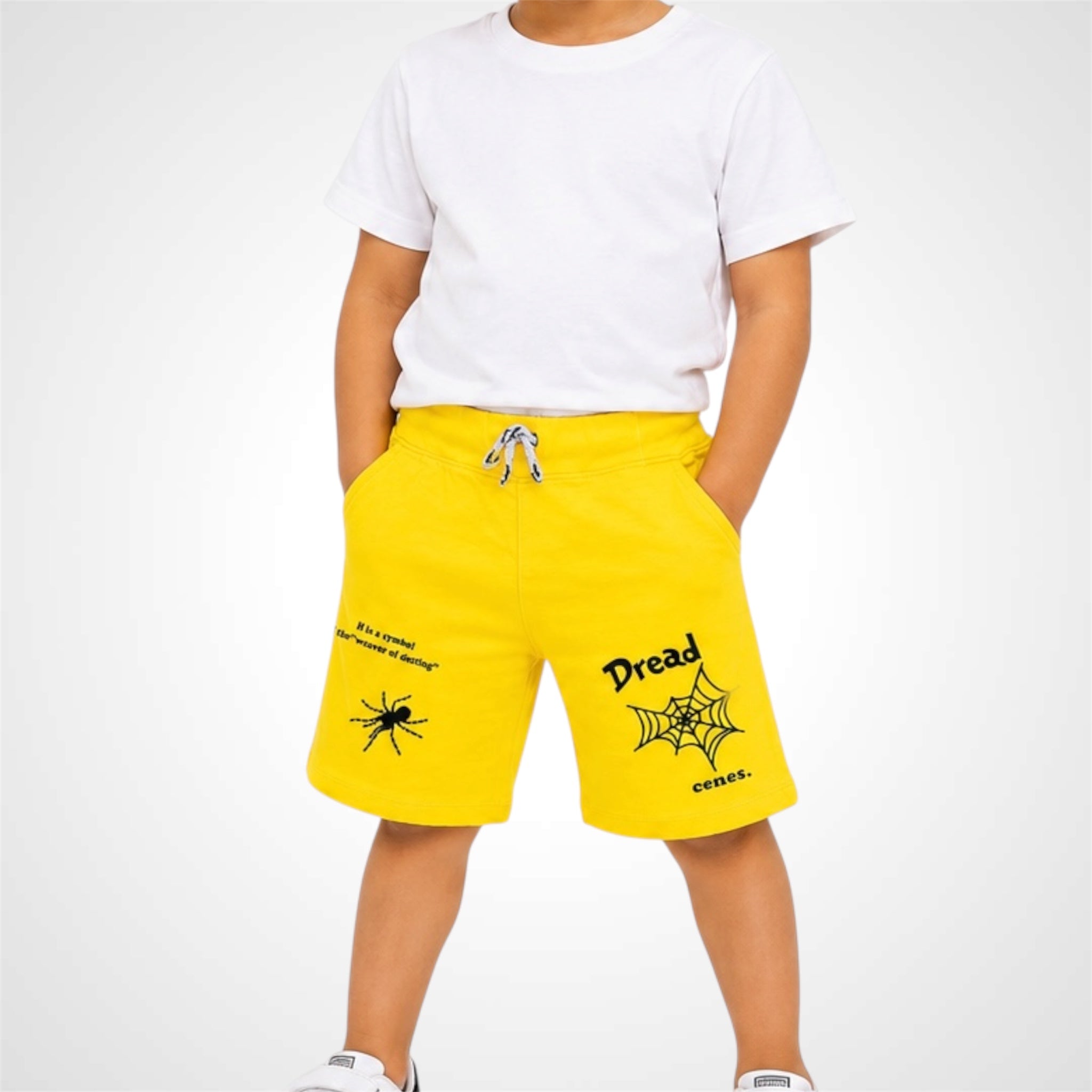 Person wearing yellow shorts with black text and graphics on a white background