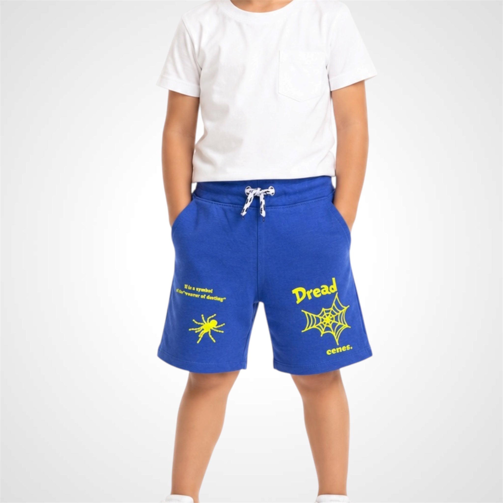 Person wearing blue shorts with yellow text and spider design on a white background