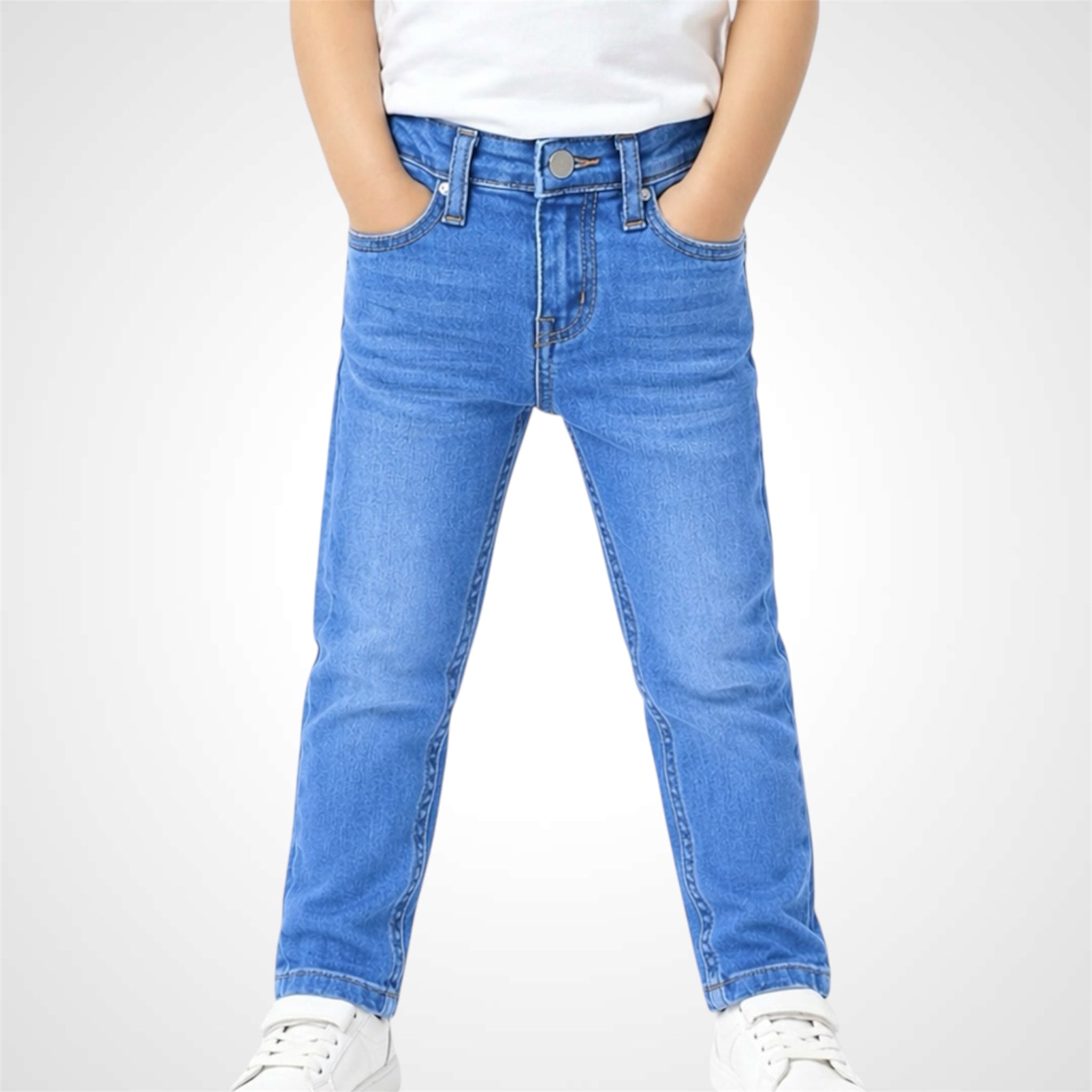 Person wearing blue jeans and white sneakers on a white background