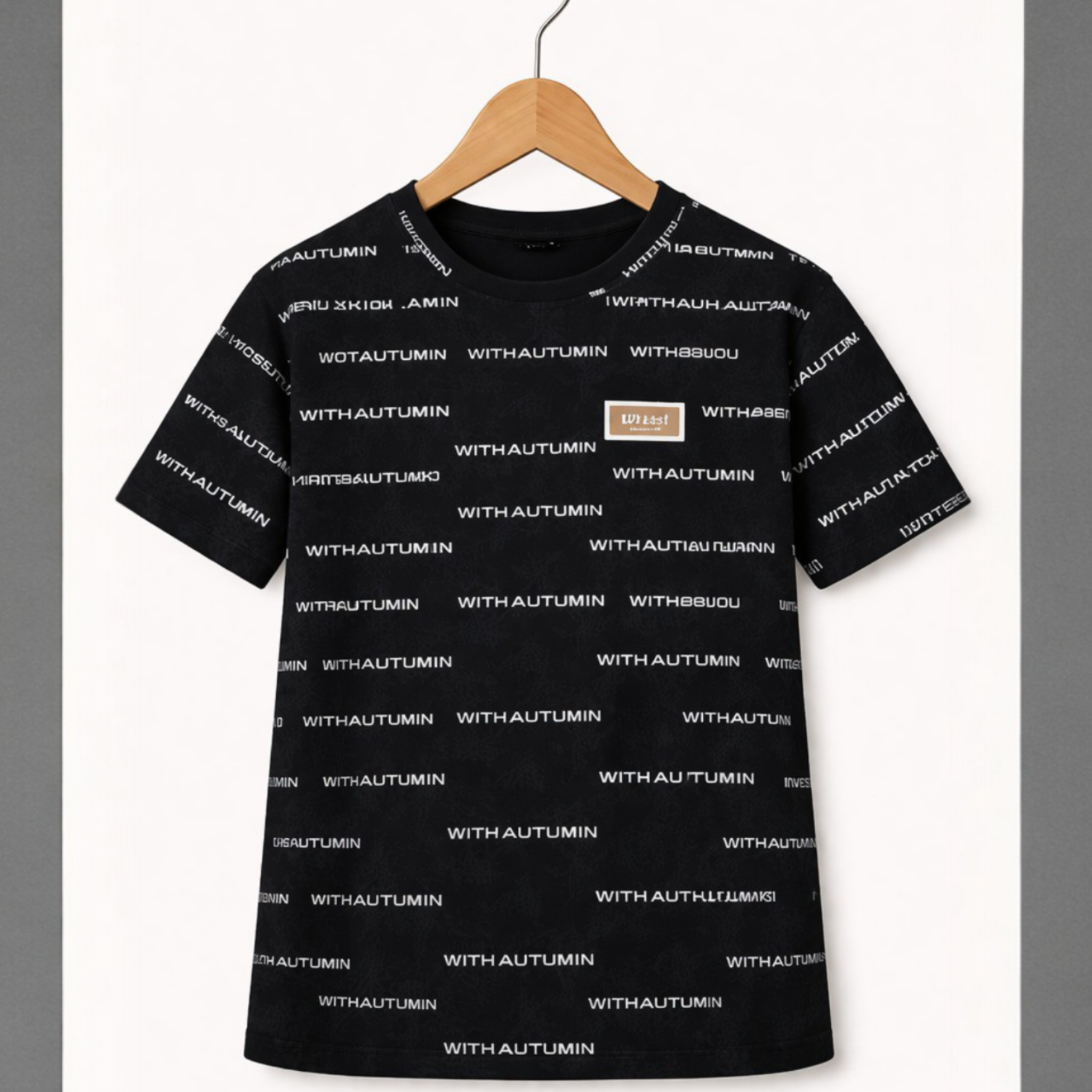 Black t-shirt with white text pattern on a hanger against a gray background