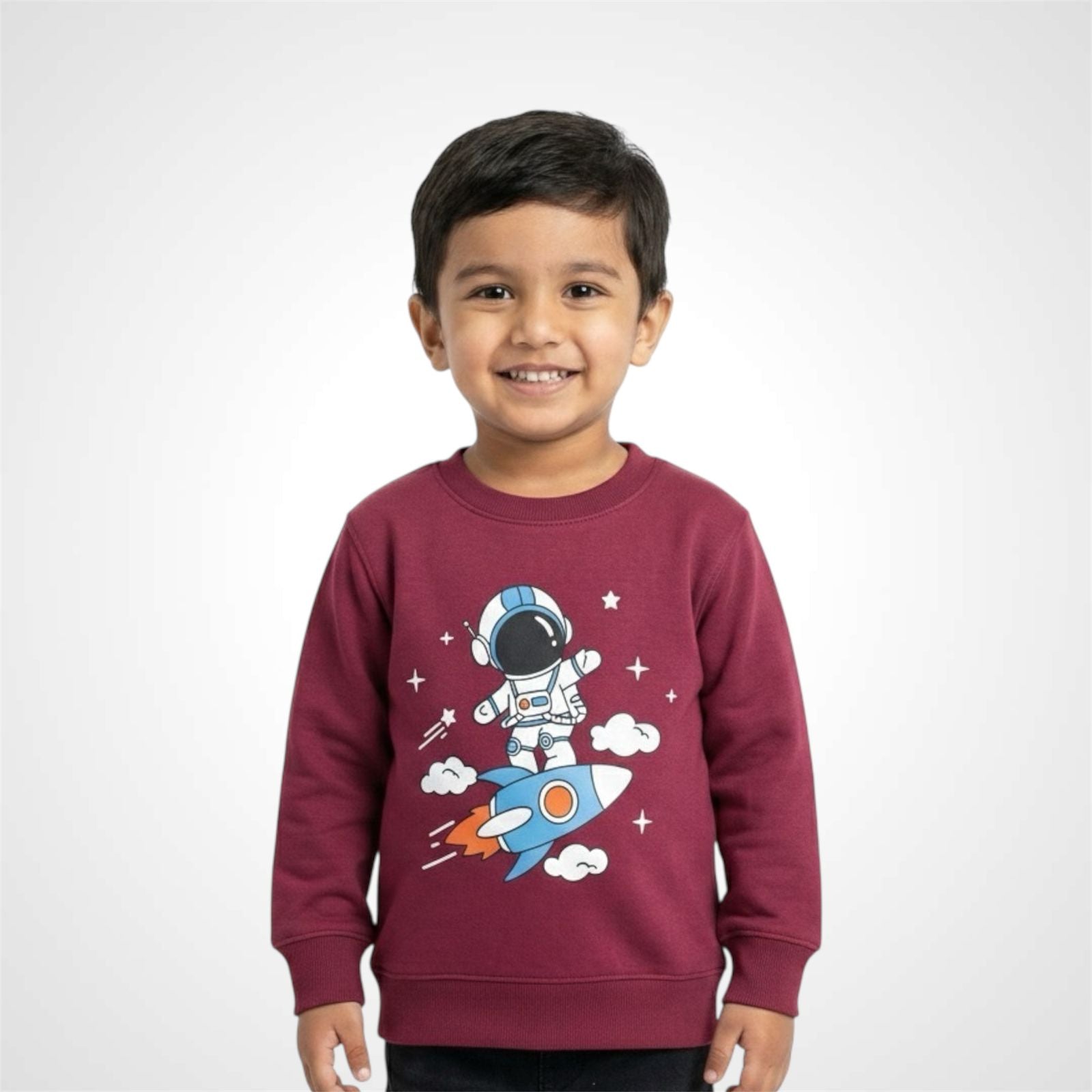 Smiling little boy wearing a grey Toddler & Boys Space Theme Sweatshirt featuring a cute cartoon Astronaut Print riding a rocket maroon